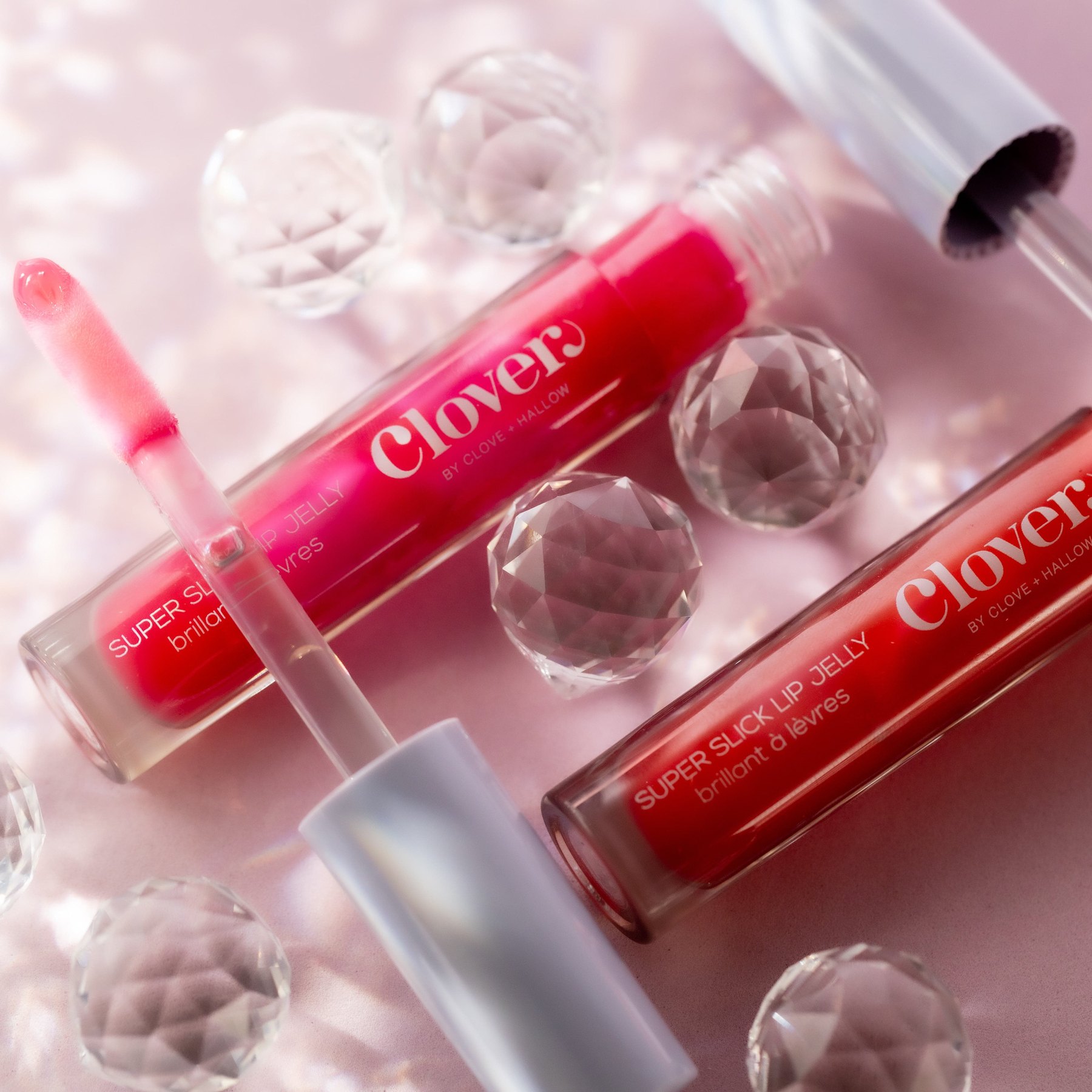 Two Super Slick Lip Jelly tubes with applicators beside crystals.