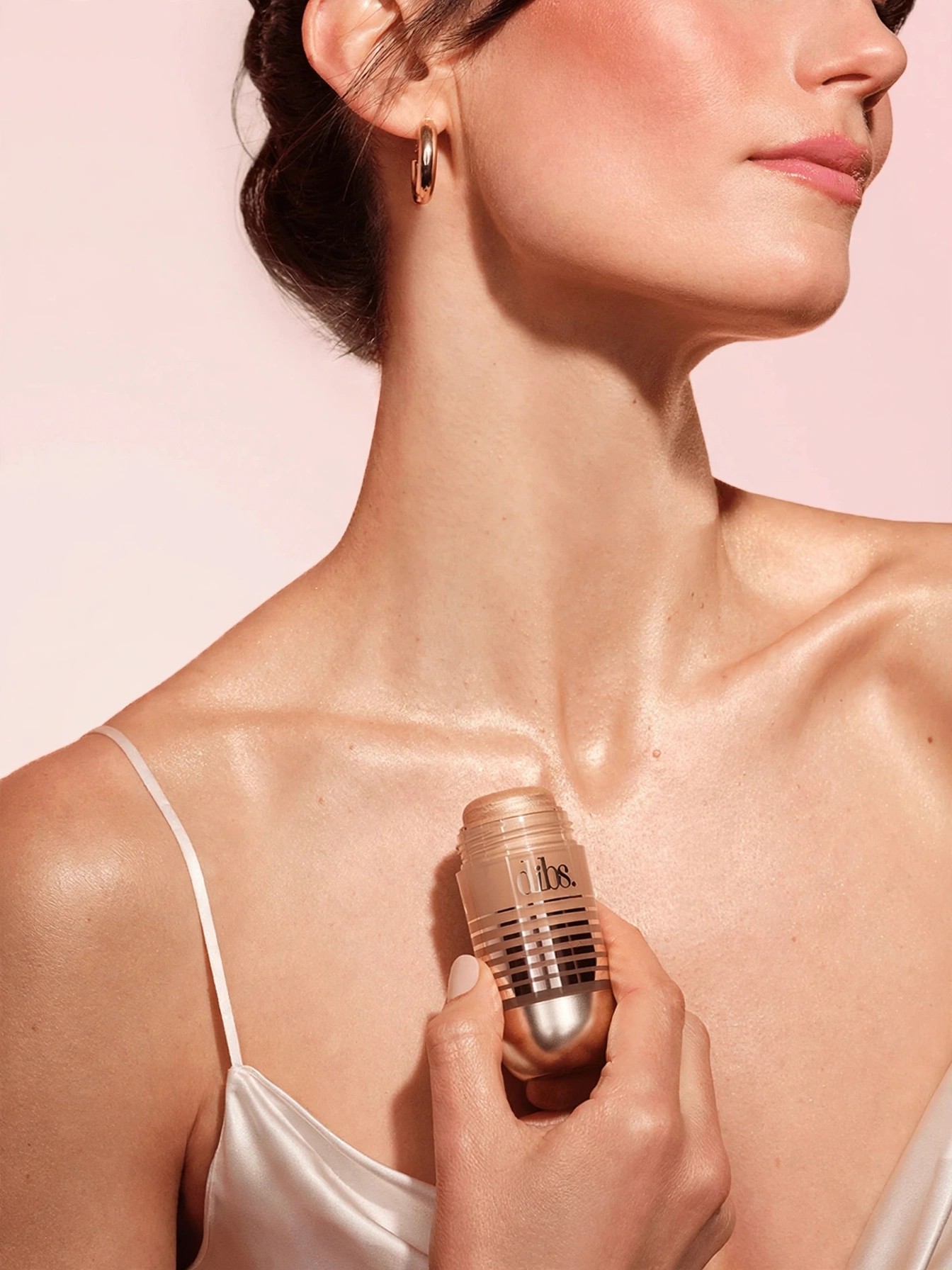 Woman holding Status Stick to her collarbone showing glow.
