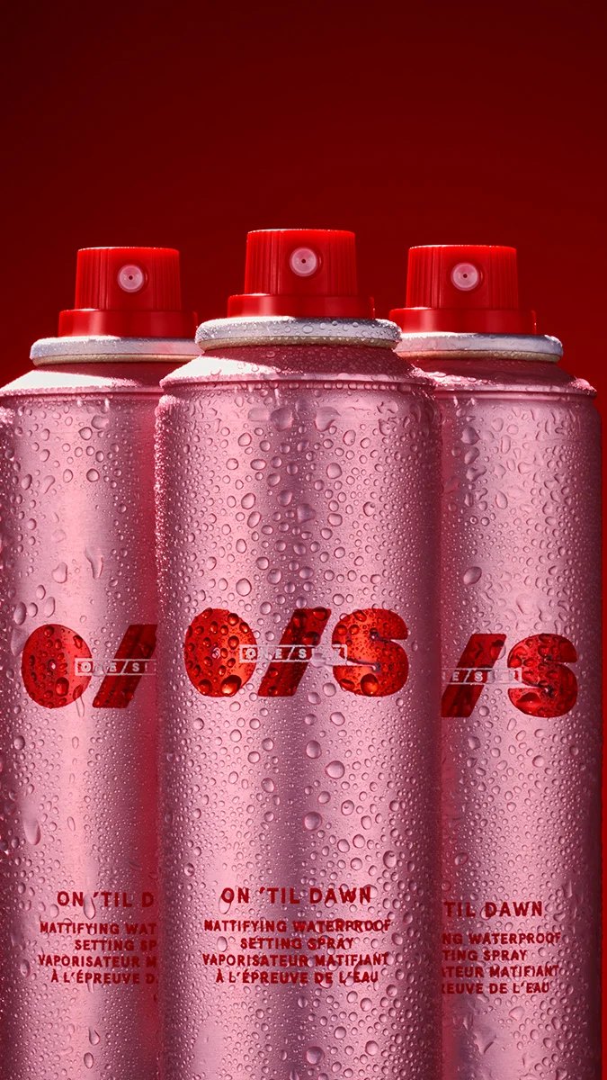 Three pink On Til Dawn cans covered in water droplets against red.