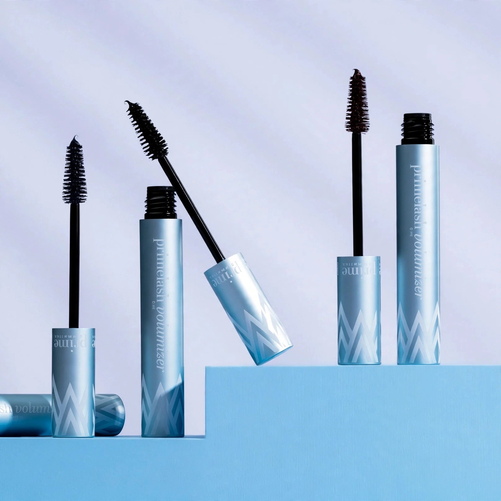 Three PrimeLash Mascara tubes with wands displayed on blue platforms.